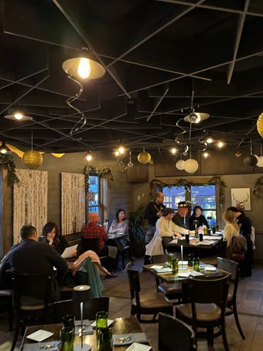 Cozy restaurant with holiday decorations and patrons enjoying meals.