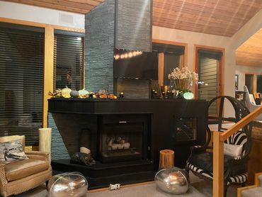 Cozy living room with a stone fireplace and eclectic furniture.