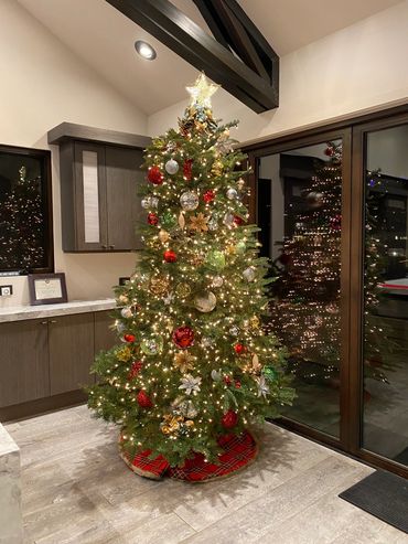 Festively decorated Christmas tree with lights and ornaments in a cozy room.
