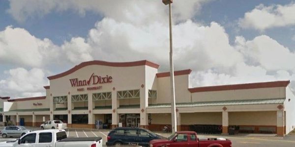 Winn-Dixie supermarket storefront with parked cars.