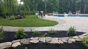 Backyard with pool, stone fire pit, and outdoor seating.