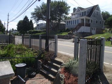 A residential street with fences and houses.