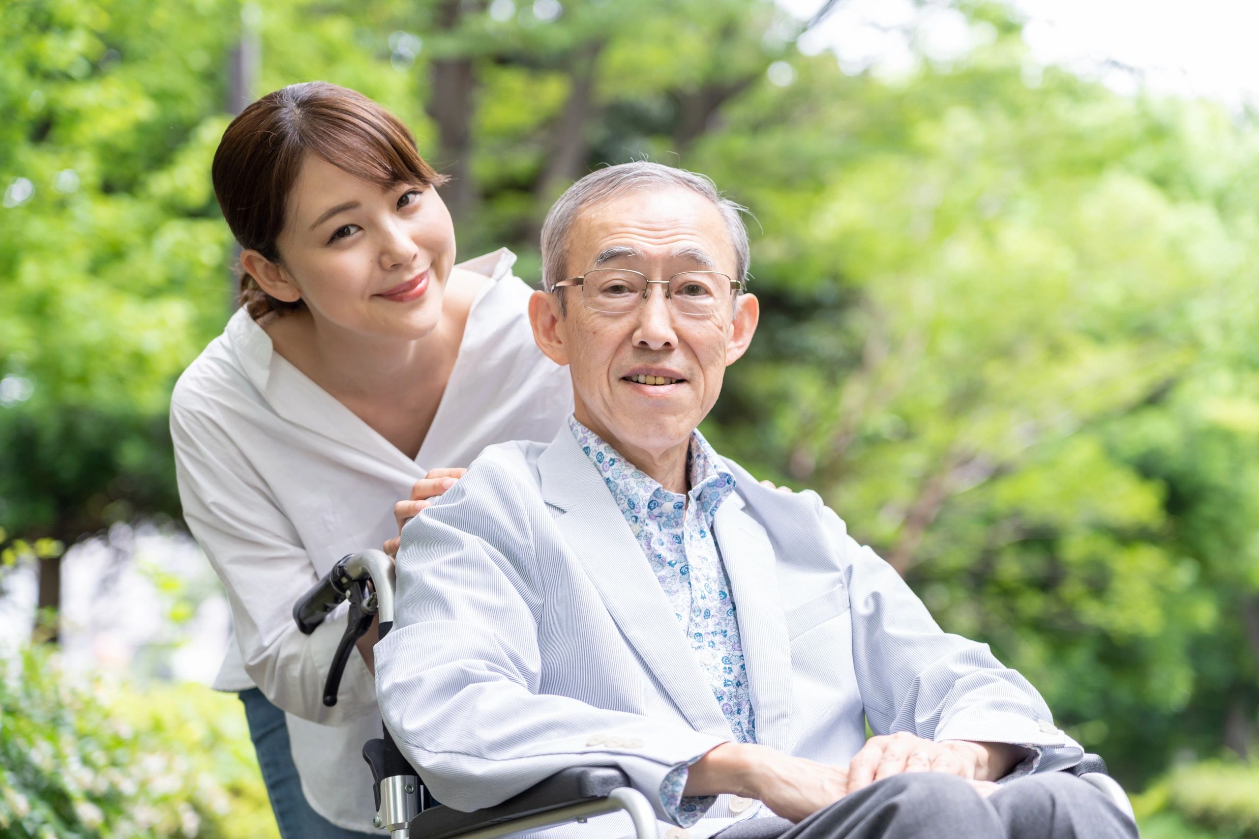 Man in a wheelchair being pushed by a young lady.