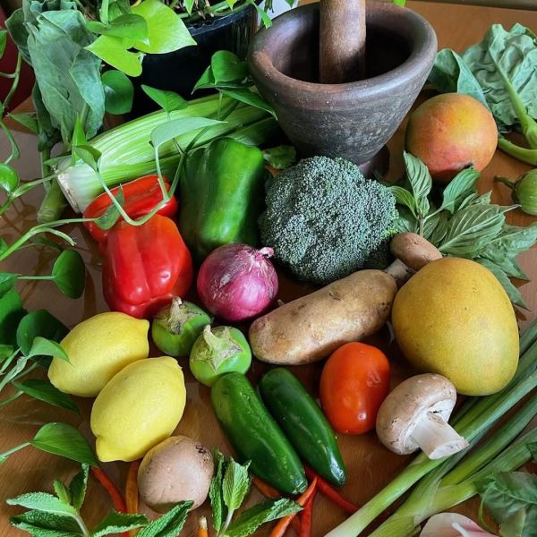 Fresh vegetables and fruits with a wooden mortar and pestle.