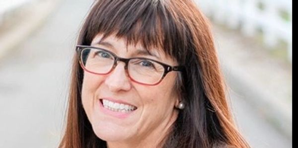 Lady smiling with glasses on.