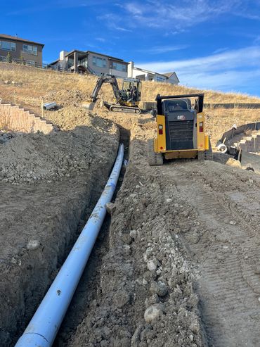 Construction site with excavators working on pipe installation.