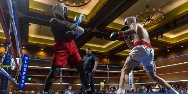 Two boxers in a ring preparing to fight with a referee watching closely. Jerrell Jones Mixed Martial arts boxing author