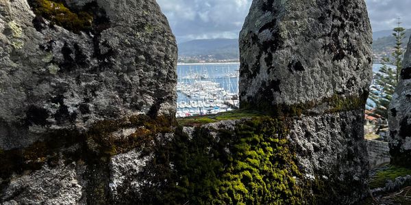 Stone on the Camino de Santiago. Portuguese Way with boats in the backgroound.