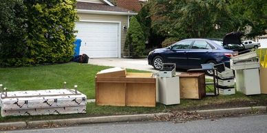 Discarded furniture and appliances on a suburban curbside.