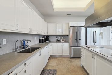 Bright, modern kitchen with white cabinetry and stainless steel appliances.