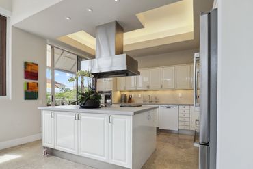 Bright modern kitchen with white cabinetry and a central island.
