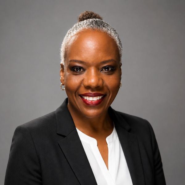 Professional woman smiling in black blazer.