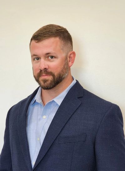 Man in a blue suit jacket and light blue shirt.
