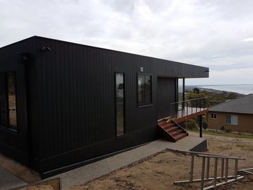 Black timber cladding exterior painting on a coastal home