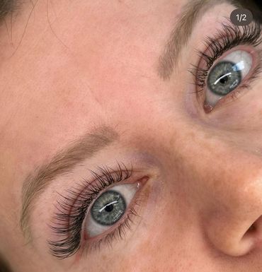 Close-up of blue eyes with long, curled eyelashes and natural eyebrows.