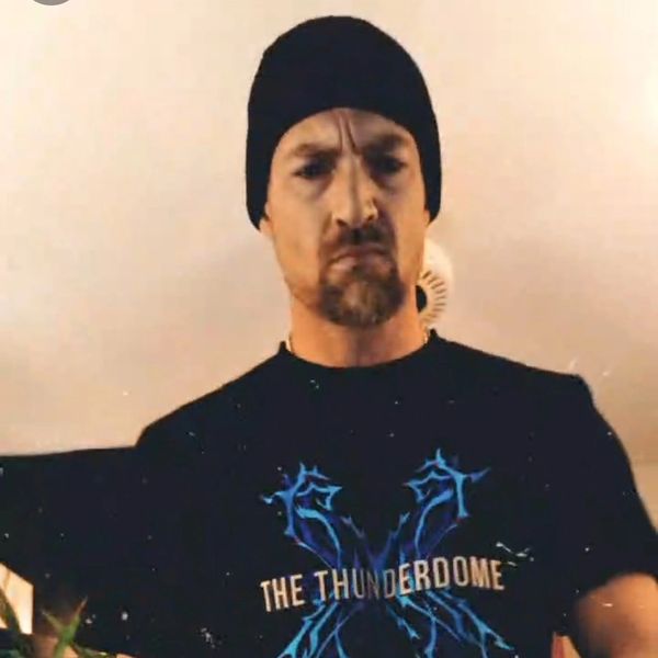Man wearing a black beanie and a Thunderdome shirt looking serious.