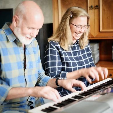 A Man playing piano and a teacher smiling.