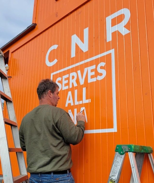 Mike hand lettering the CNR logo on the side of the caboose located at 400 Central Avenue, Fort Erie