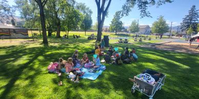 Group of children having a picnic on grass in a sunny park.