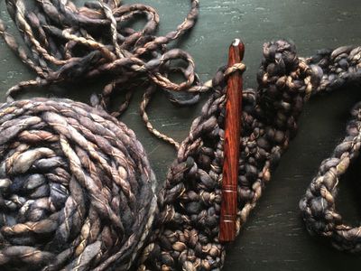 Skein of yarn, wooden crochet needle.Good for the planet crochet accessories and homegoods.