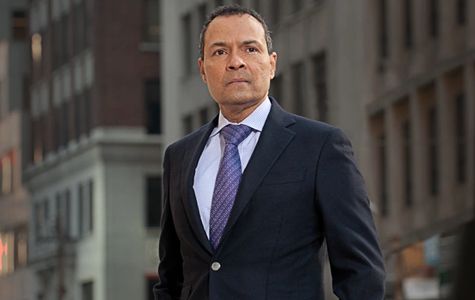 An image of marketing consultant & business consultant Dr. Sirsi standing afront a tall building.