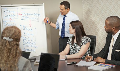 Dr. Sirsi leads a discussion while taking notes on a white board.