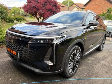 Sleek black SUV parked on a residential driveway with modern design.