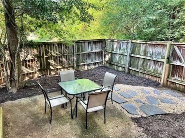 Fenced in outdoor patio area with seating
