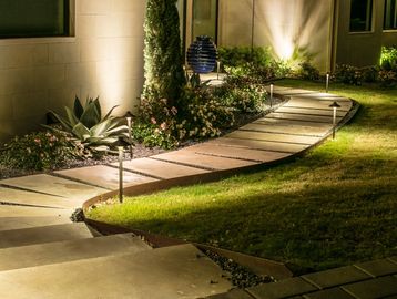 Curved garden pathway with lights at night.