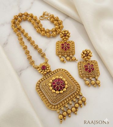 Intricately designed traditional gold jewelry with colorful meenakari and gold balls.
