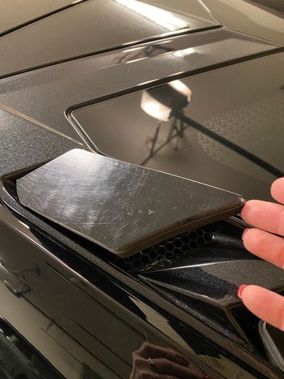 Detailed view of black hood vent and honeycomb-style grille