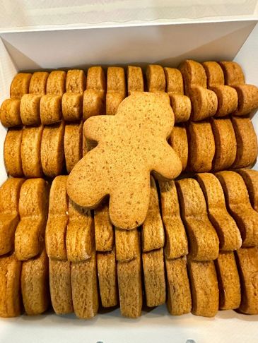 Box of gingerbread cookies with one on top.