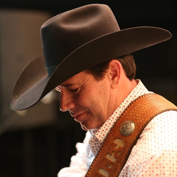 Man in cowboy hat looking down.