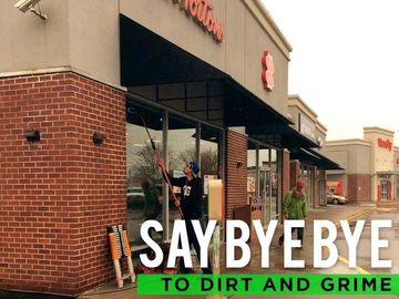 Workers cleaning the windows of a Tim Hortons storefront.