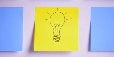 Blue and yellow post its with a lightbulb drawing for a workshop