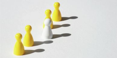 four yellow board game tokens and one white one