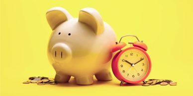 Piggybank, coins and an old-fashioned red alarmclock