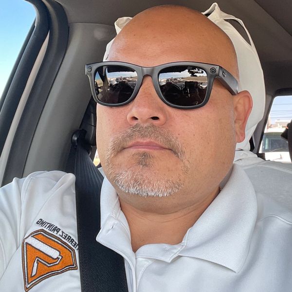 Man wearing sunglasses in a car seat.