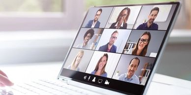 A laptop showing nine webinar attendees on the screen