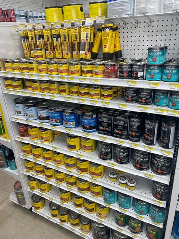 Shelves stocked with various Minwax wood finishing products in a hardware store.