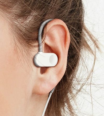 Close-up of a white earphone worn on a person's ear.