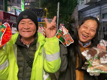 a close up of two hanuman charity beneficiaries, happy and smiling carrying christmas gifts