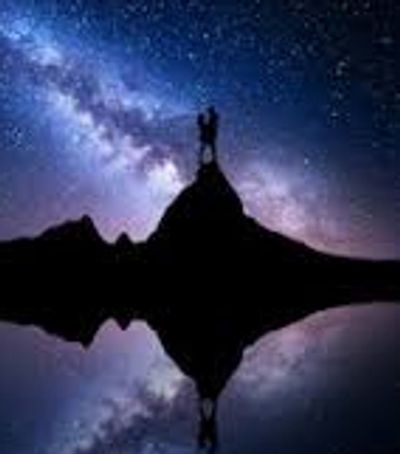 A couple standing on a mountain under the stars