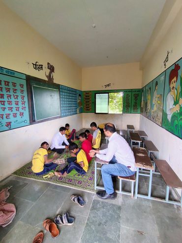 Children sitting on the floor learning with teachers in a classroom.