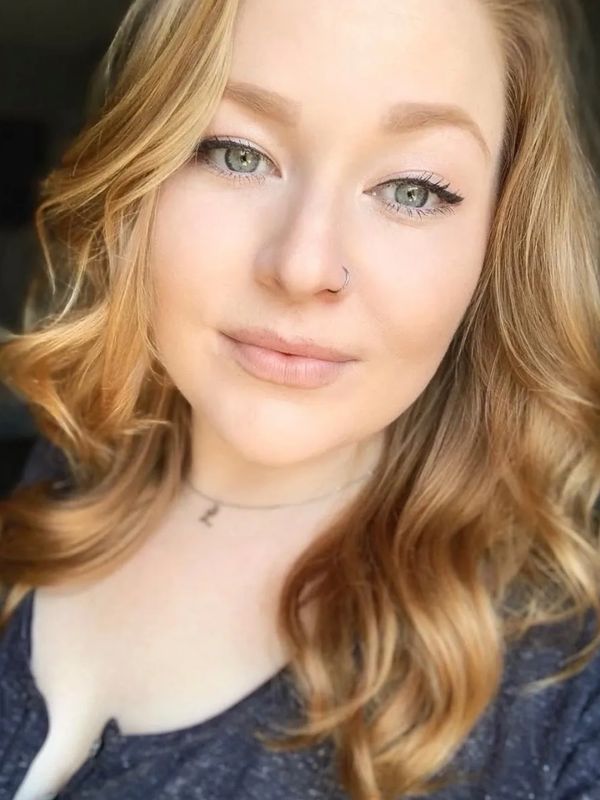 Close-up of a woman with light makeup and wavy hair.