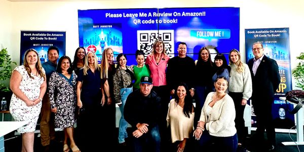 Group photo of diverse people at a book promotion event with QR codes.