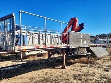 Industrial trailer with a crane on dry ground.