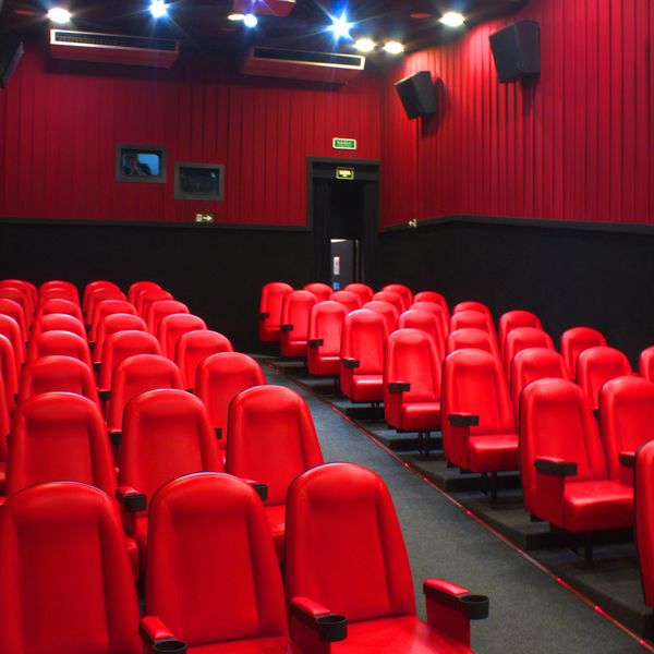 Sala de Cinema da Matilha com poltronas vermelhas, parede de tecido vermelho e preto