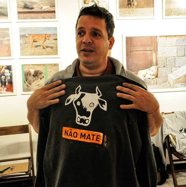 Homem com sua camiseta recém impressa por ele com a imagem de uma vaca e frase que diz: Não mate!