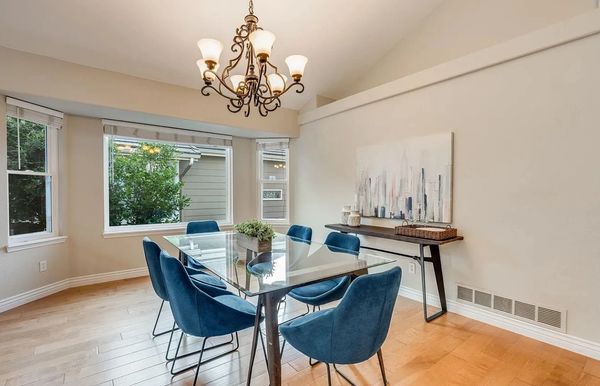 Elkegant glasstop table with vibrant blue dining chairs